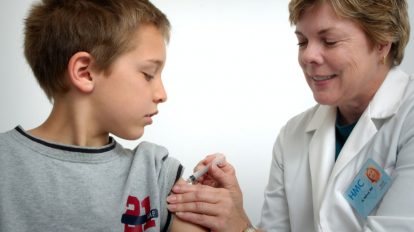 Ärztin impft Jungen